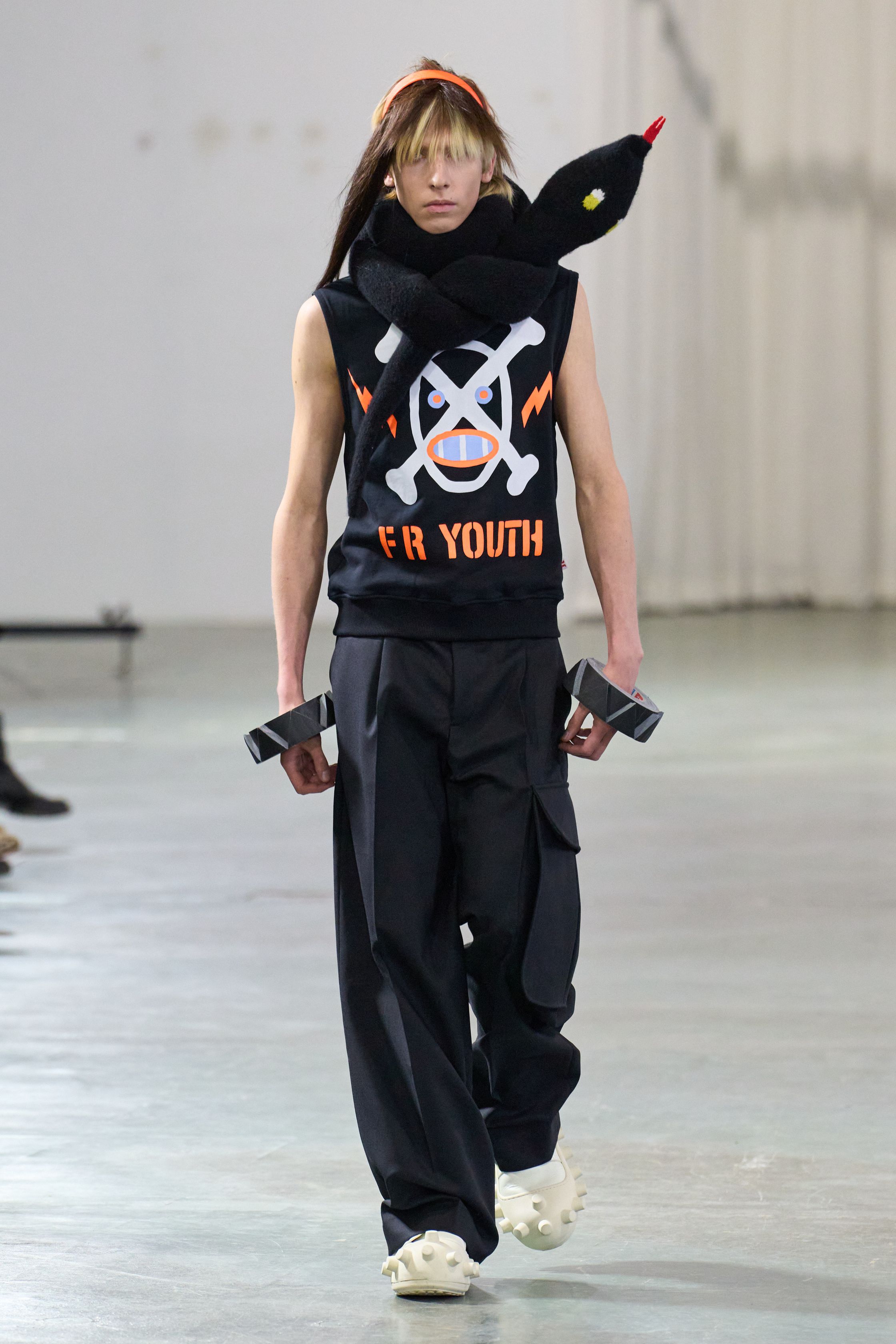 Walter Van Beirendonck 2026秋冬以高度饱和的色彩、夸张比例与童真符号继续挑战男性气质的既定边界。针织花朵、卡通图案、结构化西装与机能裤装并置，构建出介于游戏、政治隐喻与乌托邦幻想之间的舞台。系列拒绝低调，刻意制造视觉噪音，用快乐、怪诞与不合时宜的色彩作为对现实焦虑的反击，呈现一场毫不妥协的时装宣言-顽石频道趋势研究